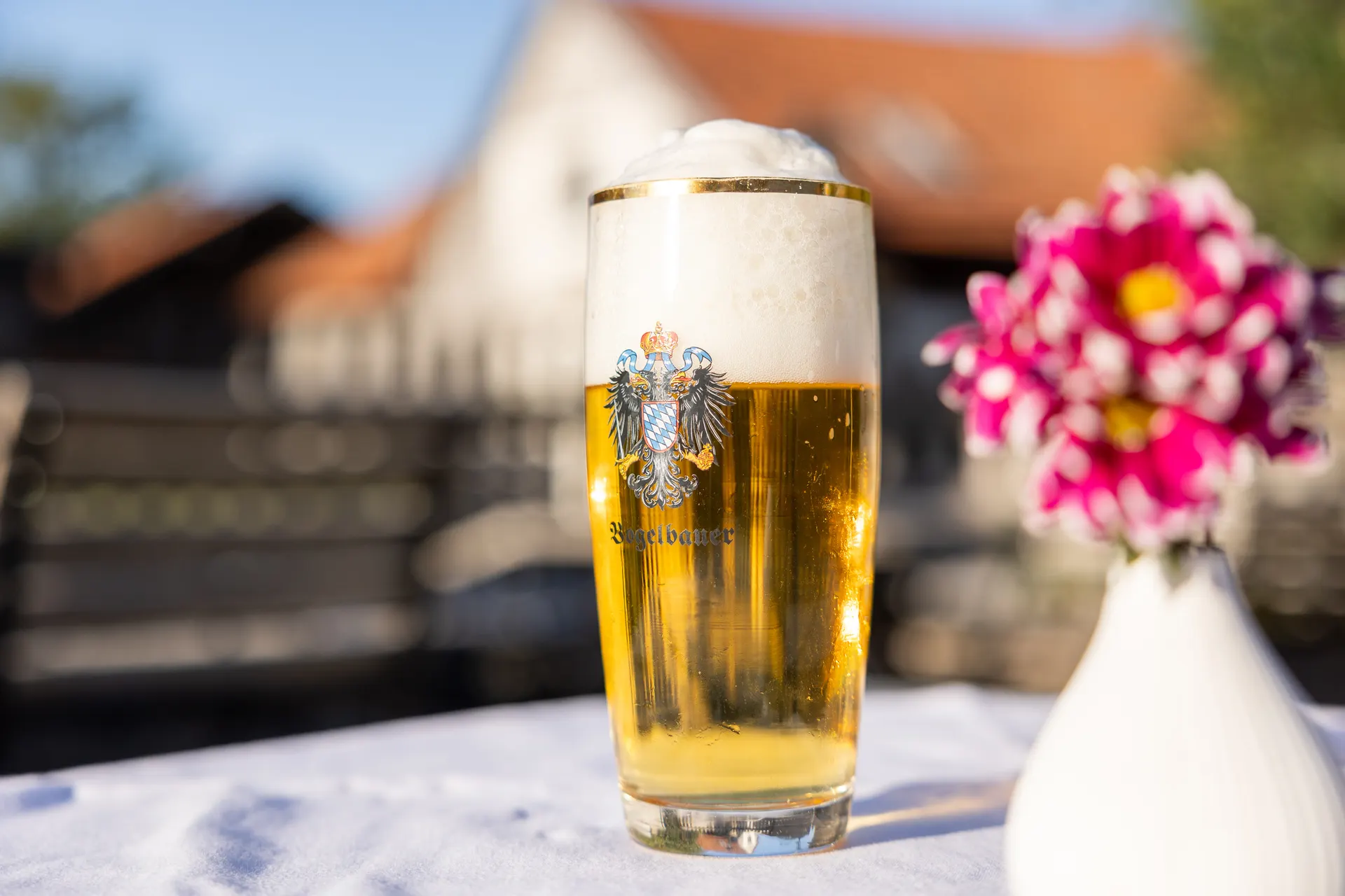 Frisch gezapftes Bier mit Blumen auf dem Tisch