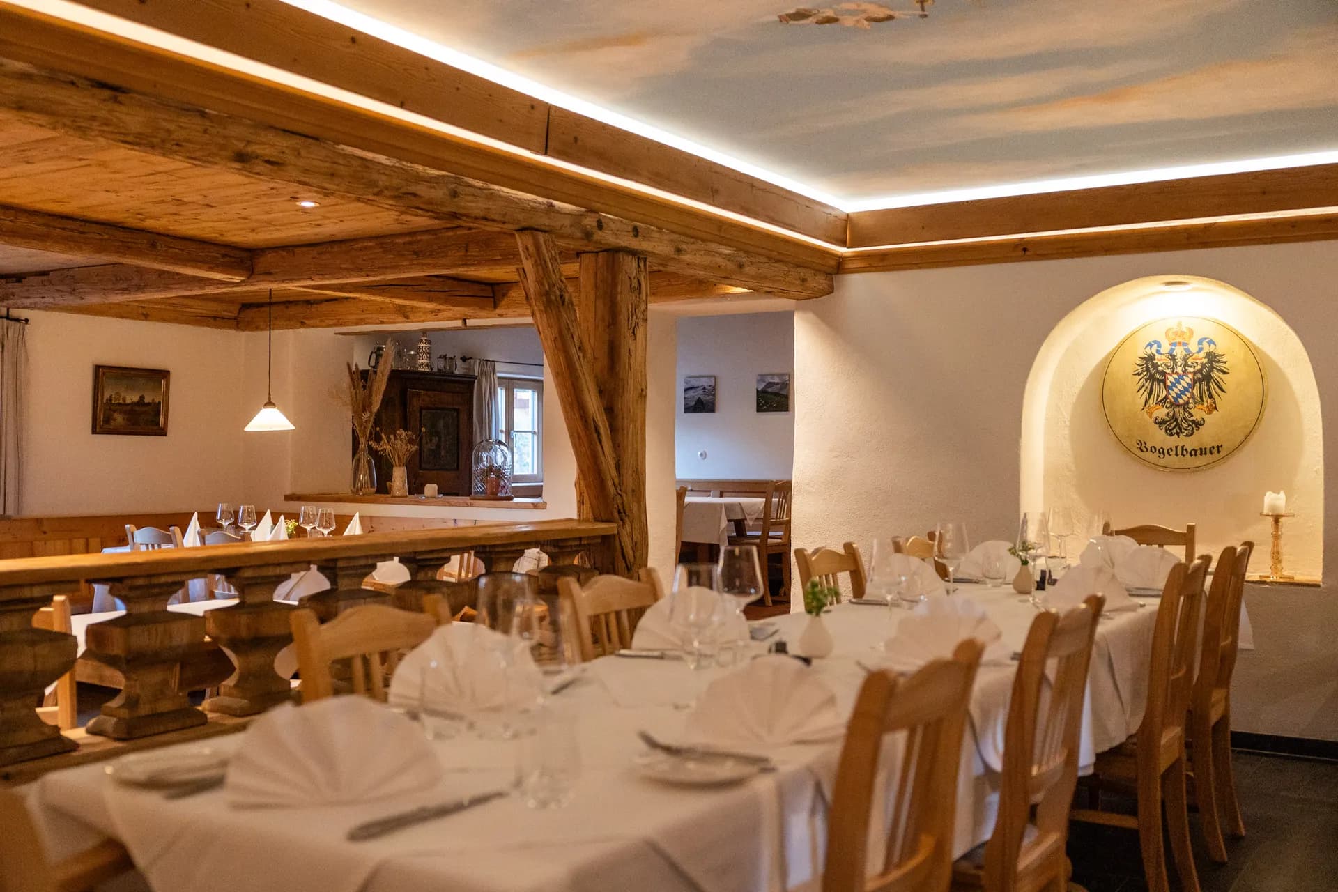 Helle Gaststube mit Holzdecke und Wappen